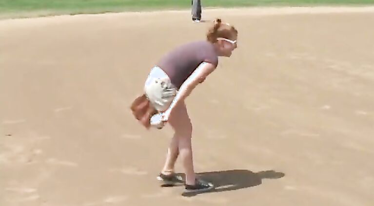 Coach shows 2 female athletes how to properly handle a big bat