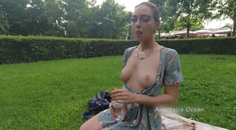 Woman relaxing in park. Flashing beautiful tits