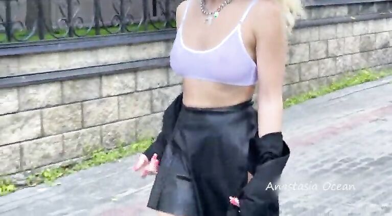 Shows breasts in the city, in a crowded place. public