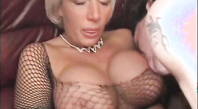 Big fake tits MILF in fishnets seduces young man to bang her